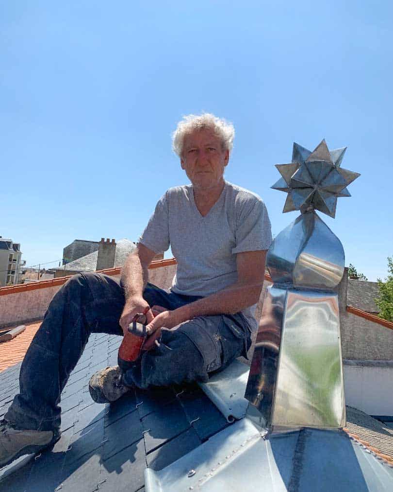 Epi de faitage en zinc sur une toiture en ardoise